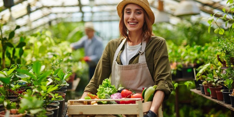Blog_Woman Holding Produce in a Greenhouse_900x450